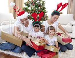 Happy family opening Christmas presents at home