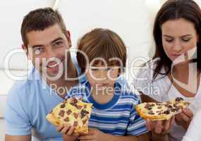 Prents and boy eating pizza in living-room