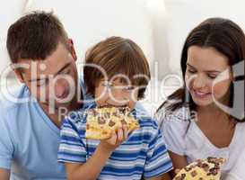 Happy boy eating pizza with ihs parents