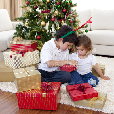 Happy brother and sister opening Christmas gifts