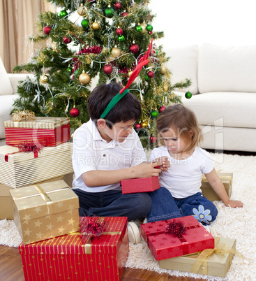 Happy brother and sister looking at Christmas gifts