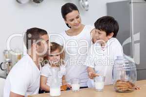 Parents and children eating biscuits and drinking milk