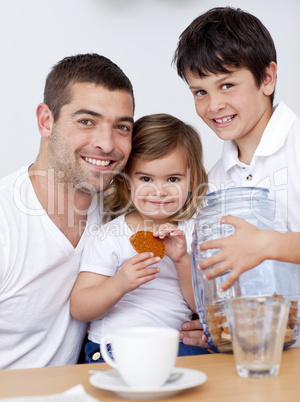 Father and children eating biscuits with milk