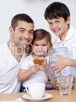 Father and children eating biscuits with milk