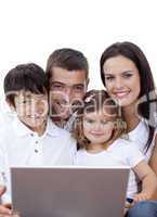 Portrait of young family using a laptop at home