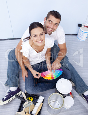 High angle of couple chosing colours to paint new house