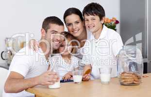 Happy family eating biscuits and drinking milk