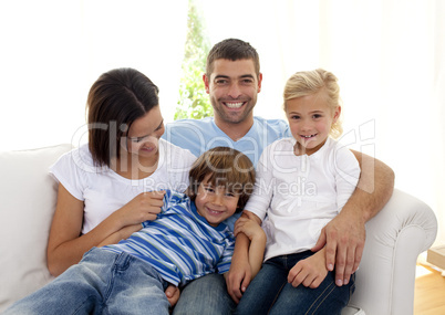 Playful family sitting on sofa at home