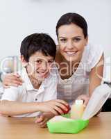 Smiling mother and son making the school lunch