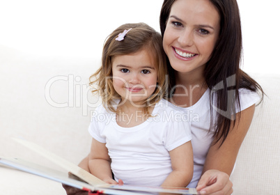 Portrait of mother and daughter reading a book
