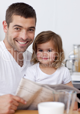 Smiling father reading a newspaper with his daughter