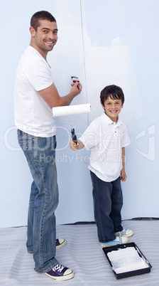 Man and little boy painting a wall