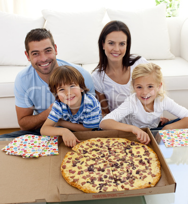 Family eating pizza on sofa