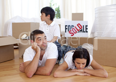 Tired family relaxing on floor after buying new house
