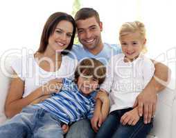 Smiling young family sitting on sofa