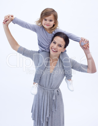 Mother giving her daughter piggyback ride against white