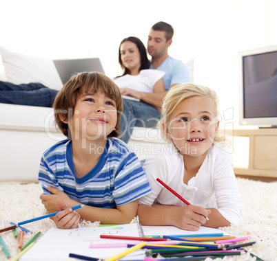 Children painting in living-room and parents on sofa