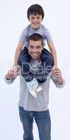 Father giving son piggyback against white