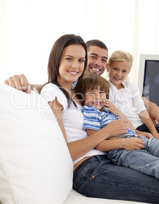 Happy parents and children sitting on sof