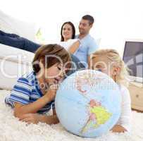 Children playing with a terrestrial globe in living-room