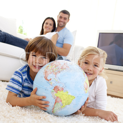 Children playing with a terrestrial globe at home