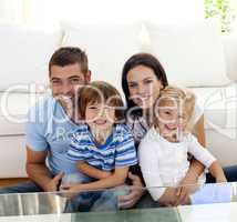 Portrait of happy family smiling in living-room