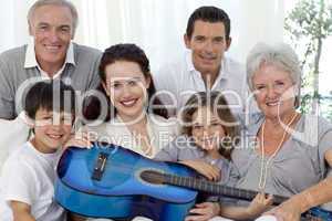 Portrait of family holding a guitar in living-room