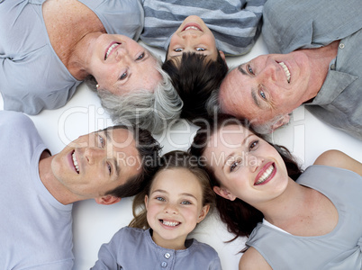 Happy family lying on floor with heads together