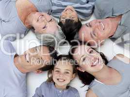 Happy family lying on floor with heads together