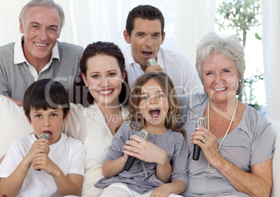 Happy family singing karaoke in living-room