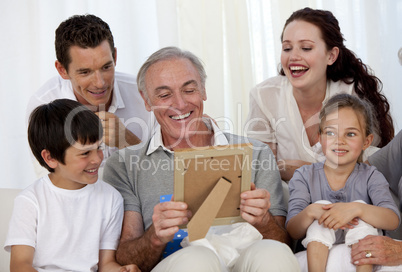 Grandfather looking at a photo with his family