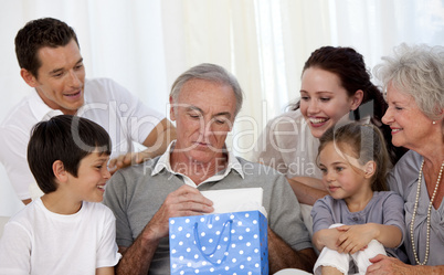 Family giving to grandfather a present