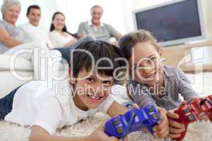 Children playing video games and family on sofa