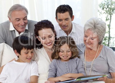 Family sitting on sofa reading a book