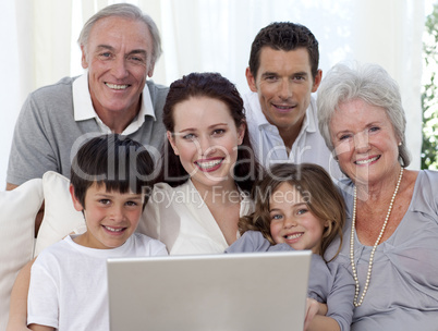 Portrait of family sitting on sofa using a laptop