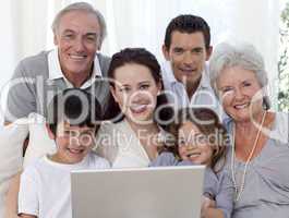 Portrait of family sitting on sofa using a laptop