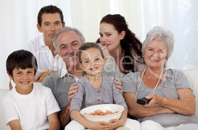 Family eating chips and watching television