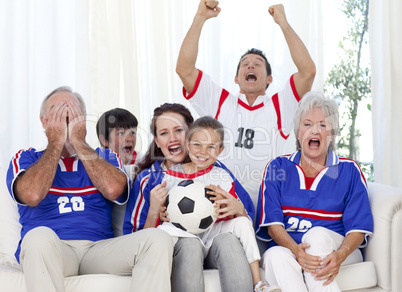 Family watching a football match in television