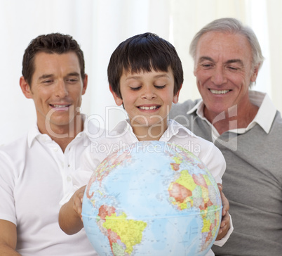 Son, father and grandfather looking at a terrestrial globe