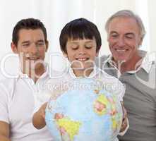 Son, father and grandfather looking at a terrestrial globe