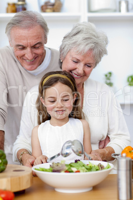 Happy grandparents eating a salad with granddaughter