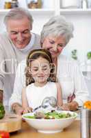 Happy grandparents eating a salad with granddaughter