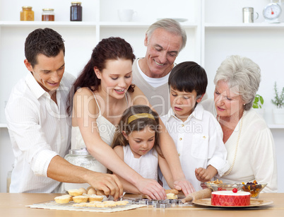 Parents, grandparents and children baking in the kitchen
