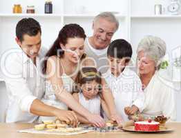 Parents, grandparents and children baking in the kitchen