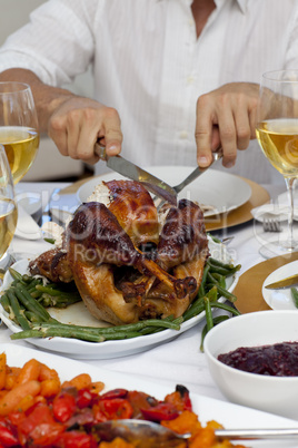 Close-up of a man cutting a turkey for Christmas dinner