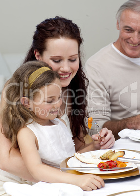 Mother and daughter eating with their family