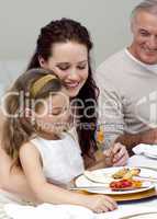 Mother and daughter eating with their family