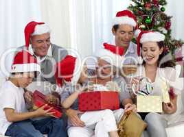 Family opening Christmas presents at home