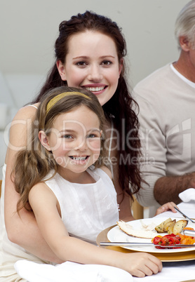 Mother and daughter having dinner with their family