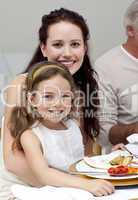 Mother and daughter having dinner with their family